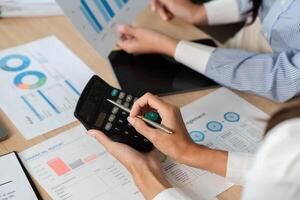 Calculating Financial Metrics. Professionals using a calculator for financial analysis and reports. photo
