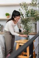 Setting up a new space. Woman arranging a plant in her home during the moving process. photo