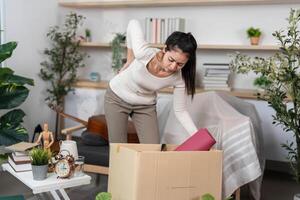 Moving and Organizing. Woman looking into a box while packing her belongings. photo