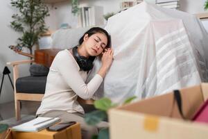 Moving and Resting. Woman taking a break while moving, resting her head on a covered object. photo