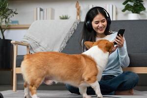 Pet Interaction and Digital Connection. Woman smiling while using smartphone as her dog approaches. photo