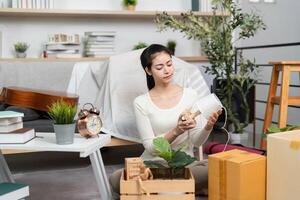 Moving and Home Organization. A young woman examining decor items while unpacking in her new space. photo