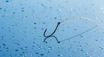 Titanium Fishing Hook on Frosted Glass With Water Droplets Casting Shadows in Natural Light photo