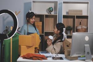 Two women are working in an office with boxes and a computer photo