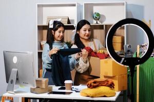 Two women are standing in front of a computer and a camera photo