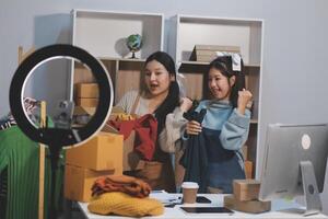 Two women are looking at a camera and a computer photo