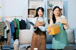 Two women in aprons holding boxes and clothes photo