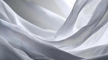 Sheer white fabric flowing elegantly in soft light creating abstract shapes and textures photo