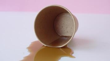 Coffee cup spills on a clean surface in bright setting video