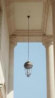 Elegant lantern hanging under architectural columns video
