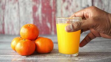 Enjoying fresh orange juice with ripe oranges on table video
