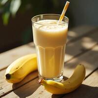Banana Smoothie in Glass with Straw and Fruit on Wood Table photo