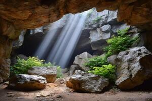 Sunbeams illuminating plants growing on rocks inside a dark cave photo