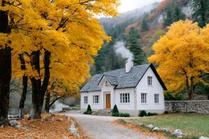 Cozy white house with smoking chimney surrounded by colorful autumn trees photo