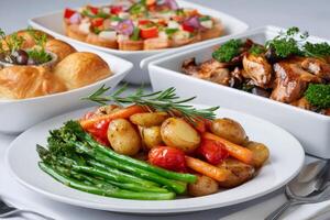 Roasted vegetables, potatoes, carrots and asparagus decorating a catering table photo