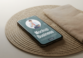 A smartphone displaying a business mockup rests on a woven placemat with a napkin beside it psd