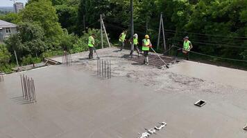 Construction Workers Pouring Concrete Slab On Rooftop Using Pump Hose And Tools, Team In Safety Vests Working On Modern Urban Building Project video