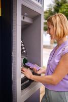 Visiting an ATM in sunny Greece during summer days photo