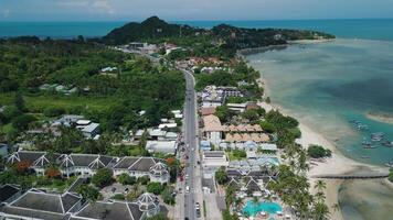 Aerial perspective on tropical beach in Thailand, white sands lined with colorful umbrellas and moored catamarans against jade water, palm canopies swaying in sea breeze. Perfect for beach-holiday video