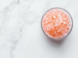 Coarse himalayan pink salt crystals in a bowl on marble surface for culinary and health use photo