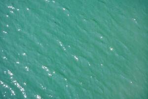 Water surface topview. Sun glare on water. Background abstracted wallpaper texture. photo