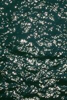 Water surface highcontrast top view. Sun glare on water. Background abstracted wallpaper texture photo