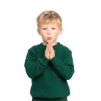 A young child in a green sweater, with hands clasped together in a gesture of contemplation or prayer, smiling softly against a white isolated background. png