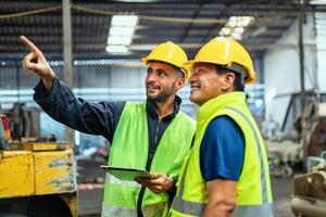 Two men in safety vests are pointing at something on a tablet photo