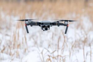 Drone Flight Over Snowy Landscape Aerial Photography and Winter Scenery. High tech drone captures breathtaking views of a snow covered landscape, showcasing the beauty of winter nature. photo