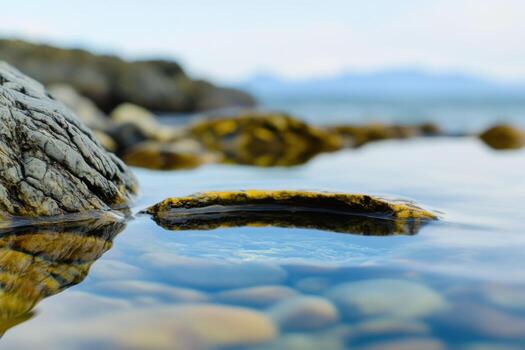 Serene Coastal Landscape Smooth Rocks and Crystal Clear Water Reflecting the Tranquil Ocean. A Captivating View of Nature's Stillness and Serenity photo
