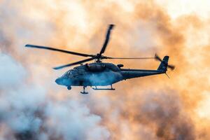 Majestic Helicopter Soaring Through a Dramatic Sunset Sky photo