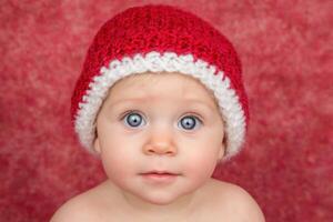 Innocent Baby with a Knitted Red Hat photo