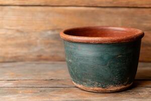 Rustic Green Terracotta Planter Pot on Wooden Background. This image showcases a vintage, aged ceramic planter with a rustic charm photo