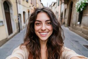 A radiant young woman smiles brightly in a captivating selfie, capturing the charm of a quaint European street. Her joyful express photo