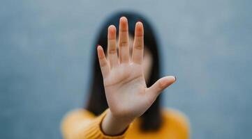 Woman's Hand Showing Stop Gesture A Powerful Symbol of Rejection, Defense, and Boundaries photo