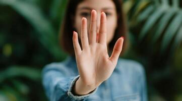 of a Woman's Hand Showing a Stop Gesture, a Powerful Image Representing Boundaries, Limits, and Non Consent. The blurred backgroun photo