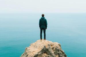 Contemplation at the Cliff's Edge A Man Gazes Upon the Vast Ocean, Finding Serenity in the Solitude of Nature's Majesty. The bound photo