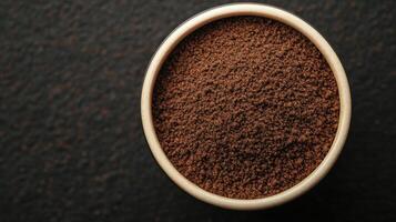 of Aromatic Dark Ground Coffee in Bowl A Rich and Intense Brew for Coffee Lovers. Discover the Exquisite Texture and Flavor of Fre photo