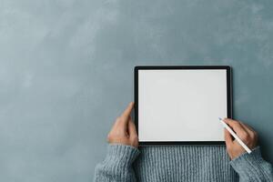 Person using a tablet with a stylus to draw or write on a blank screen. The image is perfect for showcasing technology, digital ar photo