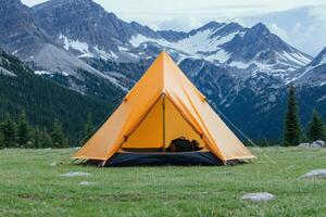 Camping Adventure in Majestic Mountains A Breathtaking Scene of a Tent Set Against a Stunning Mountain Landscape. Perfect for Trav photo