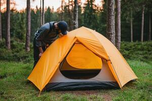 Setting up a Yellow Tent in a Forest Camping Adventure in Nature. Explore the great outdoors, enjoy the journey, embrace the freed photo