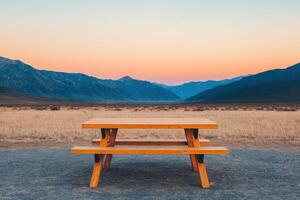 Majestic Sunset Landscape A Serene Picnic Table with Breathtaking Mountain Views. Perfect for travel, adventure, and relaxation. photo