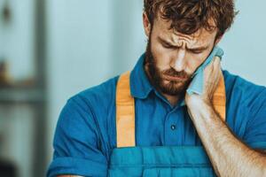 A portrait of a weary worker, his face etched with exhaustion and sadness. The image evokes feelings of stress, fatigue, and the c photo