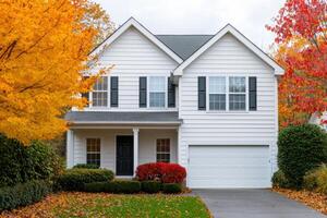 Dream Suburban Home in Vibrant Autumn Colors. White House with Garage, surrounded by colorful fall foliage. Perfect family home in photo