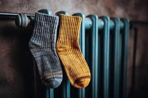 Cozy Knitted Socks Drying on a Vintage Radiator A Symbol of Warmth and Comfort for the Home. Perfect for cold winter days, these w photo