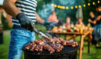 Grilling ribs at backyard party with friends enjoying food and drinks photo
