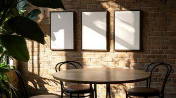 Empty frames in cafe with table, chairs, plant, brick wall photo