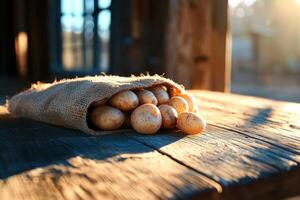 Potatoes spilling from burlap sack on rustic table at sunset photo