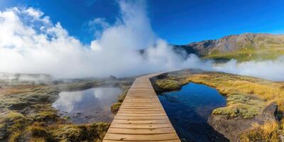 Boardwalk crosses active thermal pools, Icelandic mountains in background photo