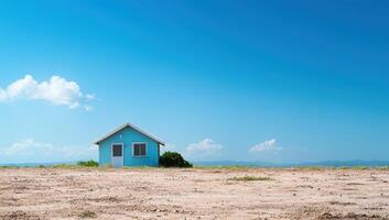 Small house stands in field, blue sky, clouds, mountains. Real estate promo photo